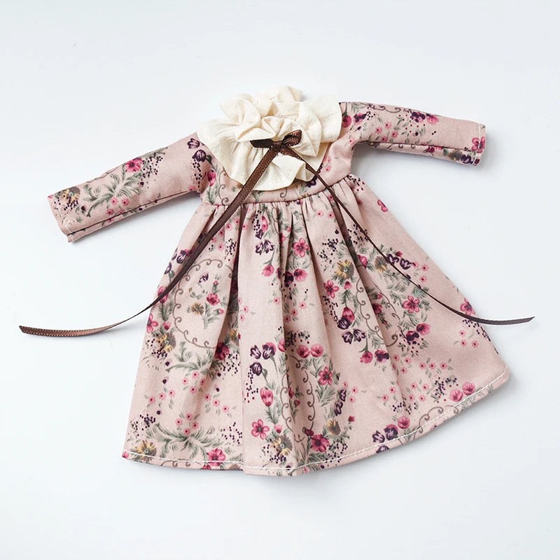 Vintage lace pajama set for a doll featuring a pink floral print and a fabric bow