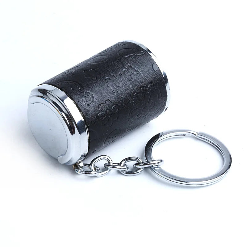 A black cylindrical coin holder keychain with a silver rim and a split ring.