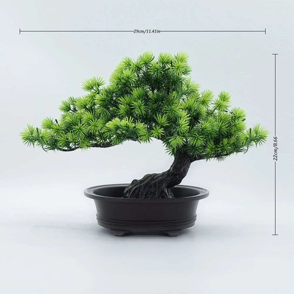 A small artificial bonsai tree with green needles planted in a black pot.
