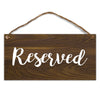 A dark brown wooden sign with the word Reserved written in white script, featuring natural twine for hanging.