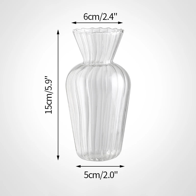 A tall, clear glass vase with a fluted rim and vertical ribbing, shown from the side.