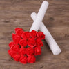 A bouquet of red roses next to a white foam flower arrangement cylinder.