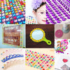 A collection of colorful self-adhesive rhinestones and embellishments used for crafting projects.