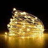 A bundle of warm yellow fairy string lights creating a glowing, tangled shape against a dark background.
