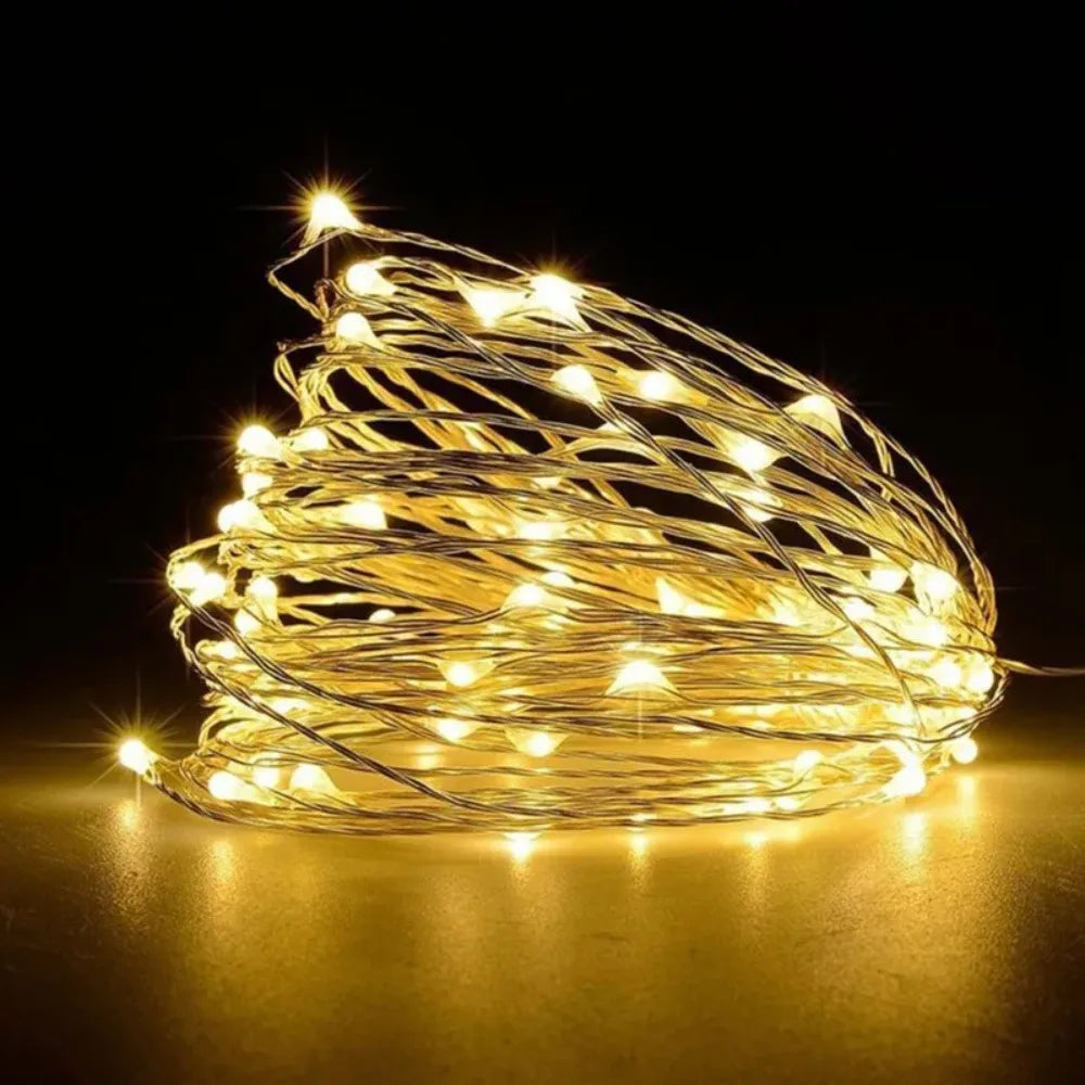 A bundle of warm yellow fairy string lights creating a glowing, tangled shape against a dark background.