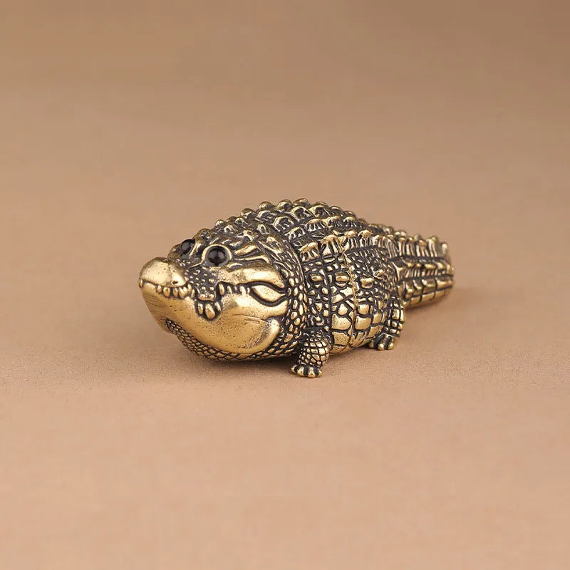 Antique brass crocodile figurine with detailed texture, used as vintage desk decor.