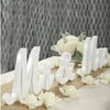 White wooden MR & MRS decorative letters for weddings and home displayed on a table with white flowers.