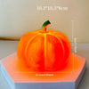 An orange decorative LED pumpkin night light resting on a white square base.