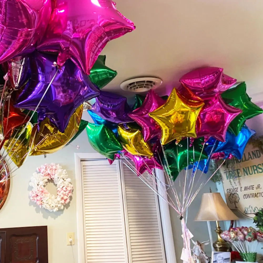 Un amas de ballons en papier d'or et violet suspendus au plafond.