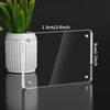 A transparent acrylic photo frame with a magnetic display stand and a white cylindrical pot of green plants.