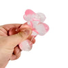 A hand is holding a pink and white squishy stress relief toy shaped like a dachshund.