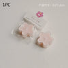 A single pink flower-shaped soy wax tea light candle is shown in clear packaging.