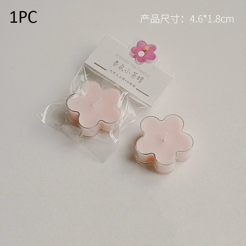A single pink flower-shaped soy wax tea light candle is shown in clear packaging.