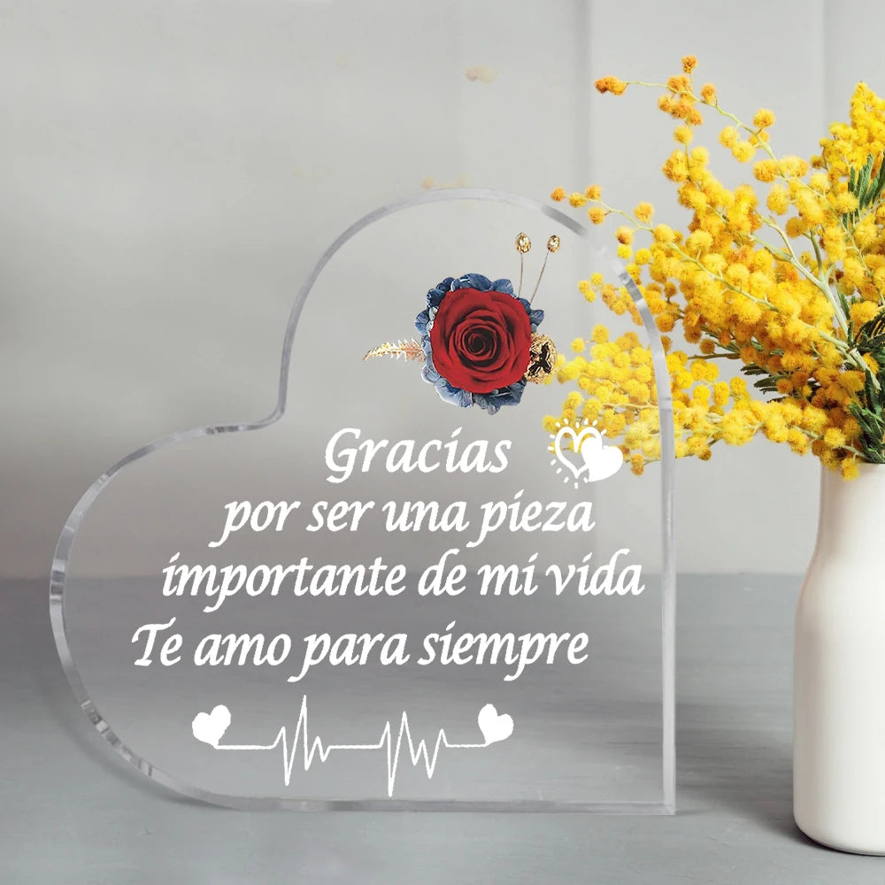 A clear heart-shaped glass keepsake with engraved text 'Gracias por ser una pieza importante de mi vida Te amo para siempre' 