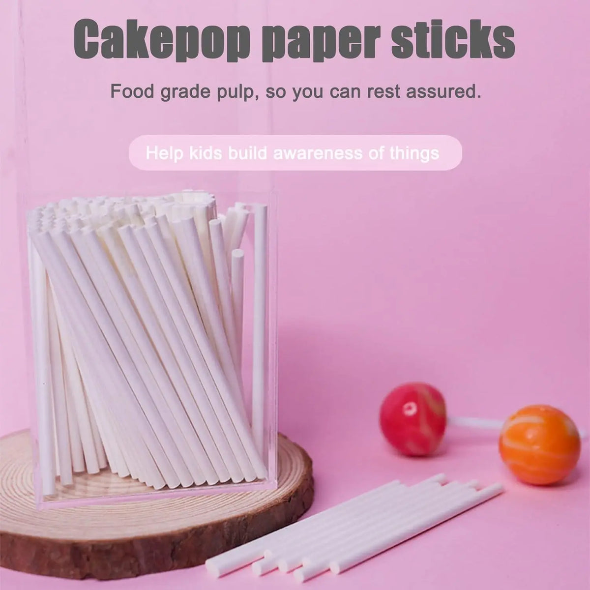 A collection of white paper lollipop sticks for cake pops is displayed in a clear container on a pink background.