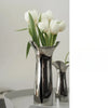 A silver-plated ceramic vase with a Nordic floral design holds white tulips.