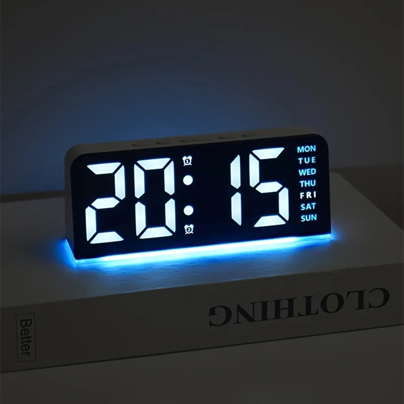 Reloj de alarma LED digital mostrando 20:15 en una superficie blanca con retroiluminación azul.