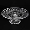 Clear acrylic serving plate with a decorative, sunburst pattern on a pedestal base.