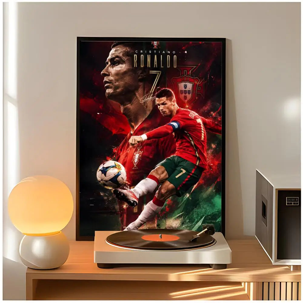 A framed poster of Cristiano Ronaldo in a red jersey and a green shorts, displayed on a wooden table.