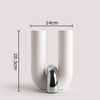 A tall, cylindrical ceramic vase with a U-shape, featuring a textured white finish and a chrome finial.