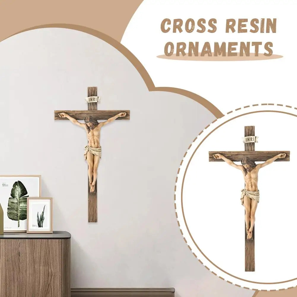 A cross resin ornament with a figure of Jesus Christ is displayed on a wall.