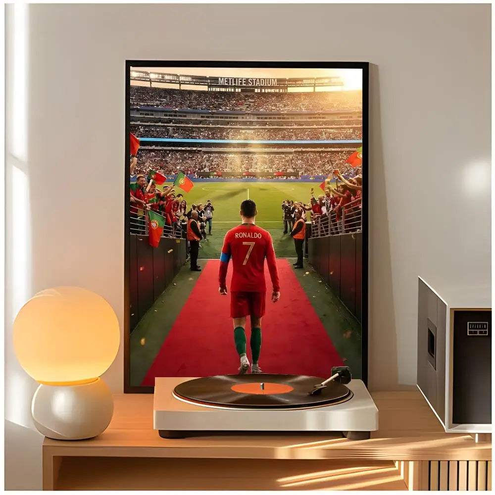 A framed poster of Cristiano Ronaldo in a red jersey standing on a green field with a red tunnel entrance.
