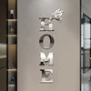 A set of metal letter wall mirror decals spelling out HOME and a butterfly, displayed on a light gray wall.