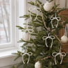 A decorated Christmas tree featuring white pearl bow ornaments and beaded garlands.