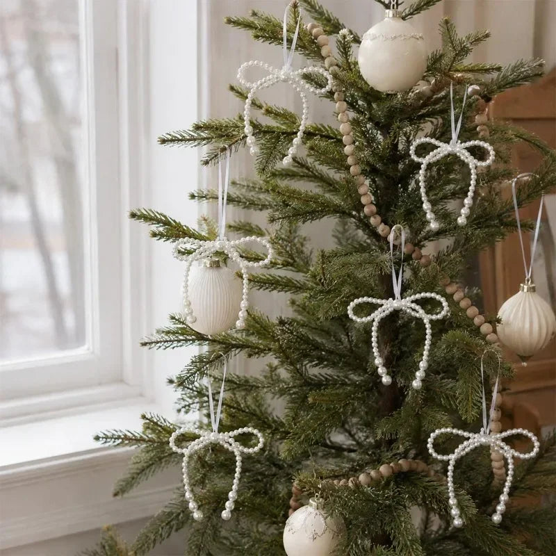 A decorated Christmas tree featuring white pearl bow ornaments and beaded garlands.
