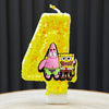 A yellow birthday cake candle shaped like the number 4, decorated with SpongeBob SquarePants characters.
