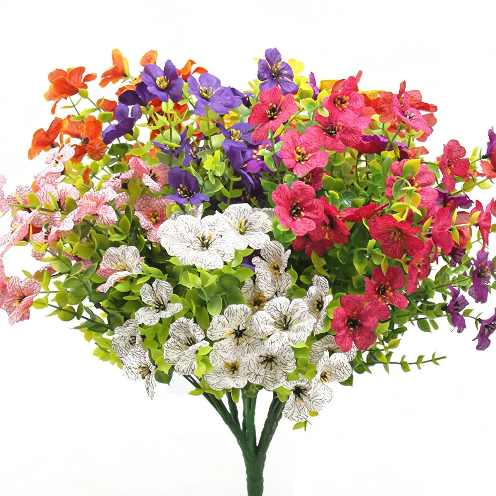 Eine leuchtende Blumensträuße aus künstlichen Frühlingsmargeriten in Rosa-, Rot-, Lila- und Orangetönen auf einem grünen Stie