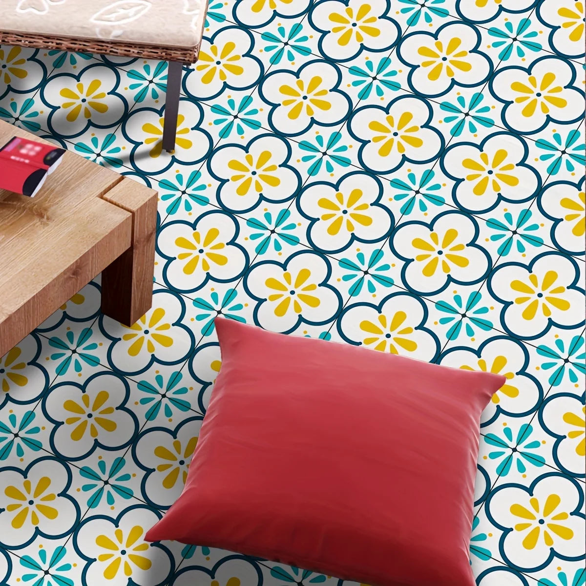 A red cushion rests on a brightly patterned floor featuring yellow and blue floral Moroccan design stickers.
