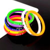 A stack of colorful silicone bracelets featuring a Jesus heart design, including green, pink, purple, and orange.