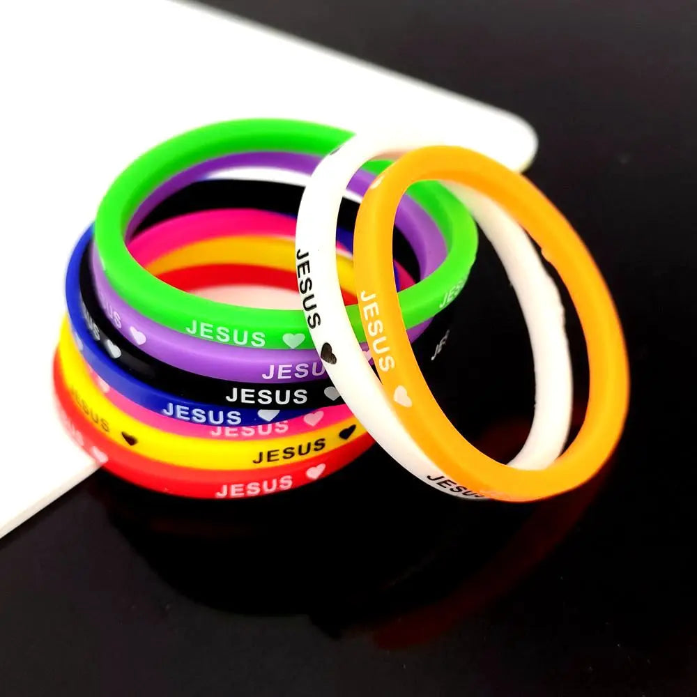 A stack of colorful silicone bracelets featuring a Jesus heart design, including green, pink, purple, and orange.