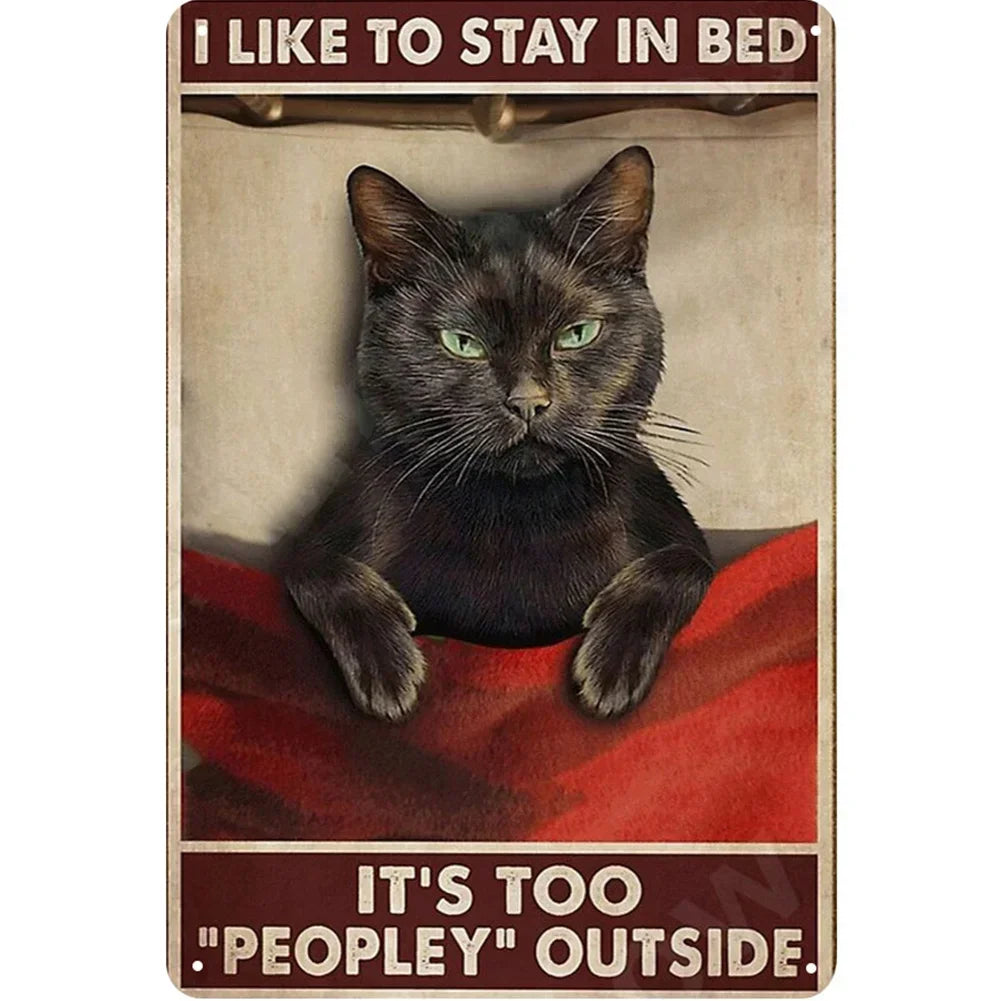A vintage metal sign featuring a black cat looking intensely at the viewer with green eyes and text that reads I like to stay