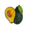 A green avocado with a yellow-orange flesh and pit, used as a fridge magnet.