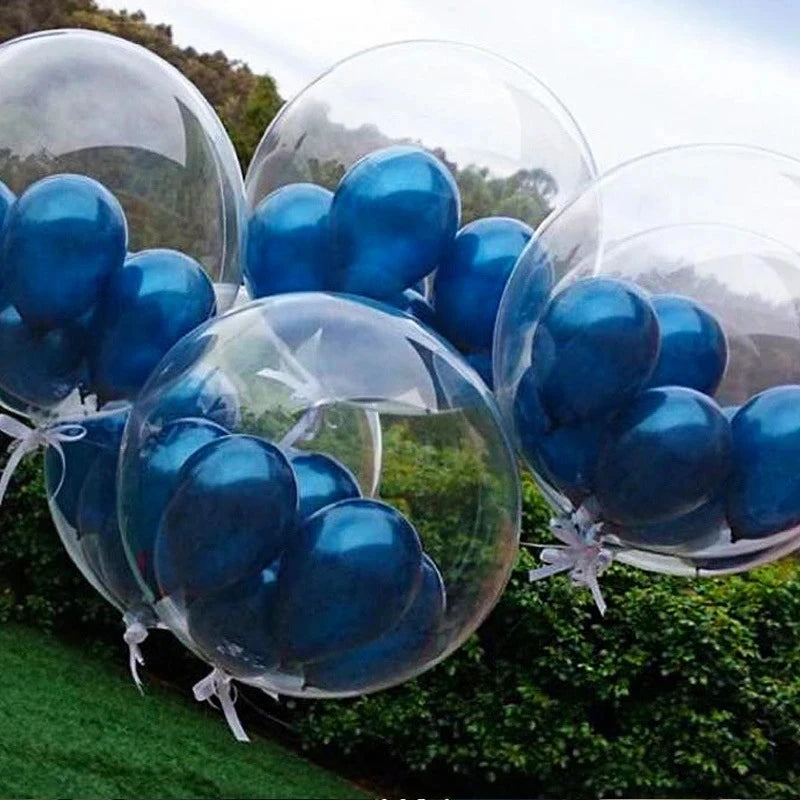 A cluster of blue transparent inflatable balloons floating above green foliage.