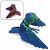 A vibrant blue parrot figurine with movable wings shown next to a smaller, similar colored bird.