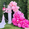 A large balloon arch display featuring pink and purple latex balloons for a baby shower or party backdrop.