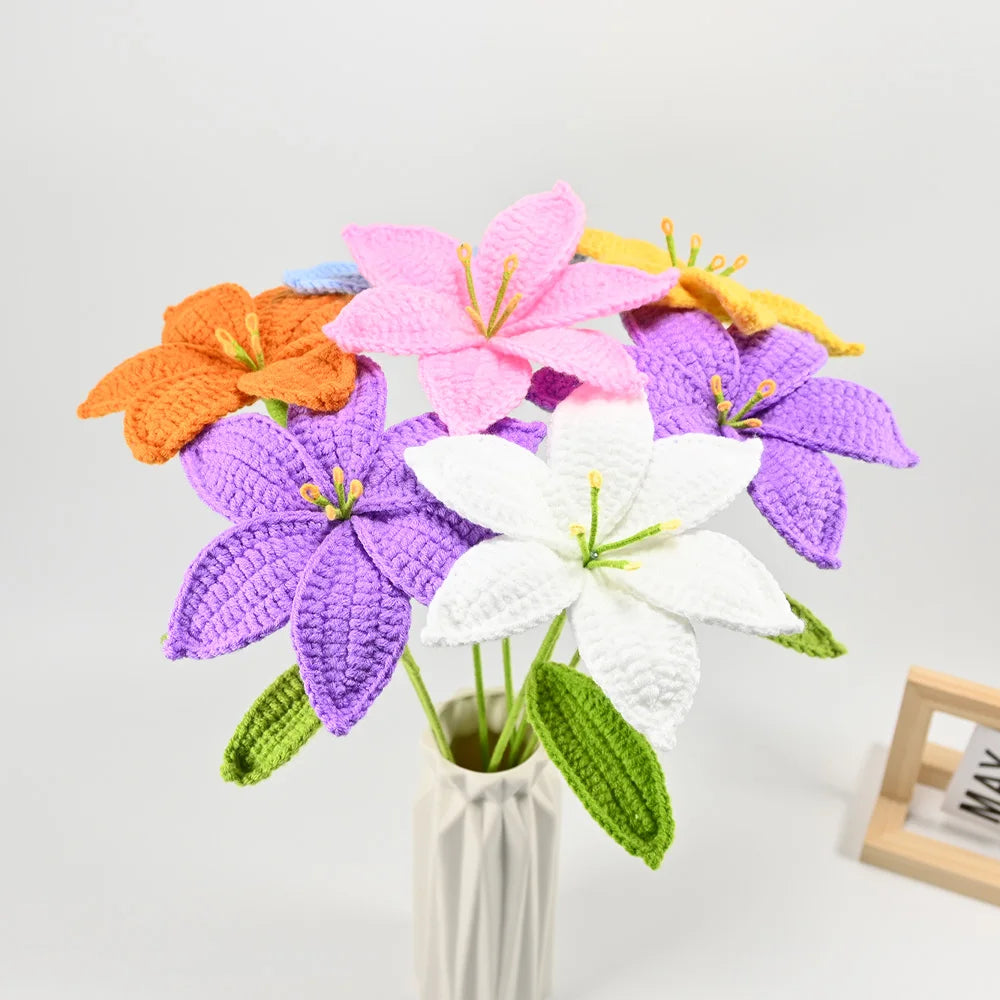 A hand-crocheted bouquet of artificial lily flowers in various shades of pink, purple, orange, and white.