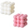 A set of two soy wax candles, one white and one pink, shaped like cubes.