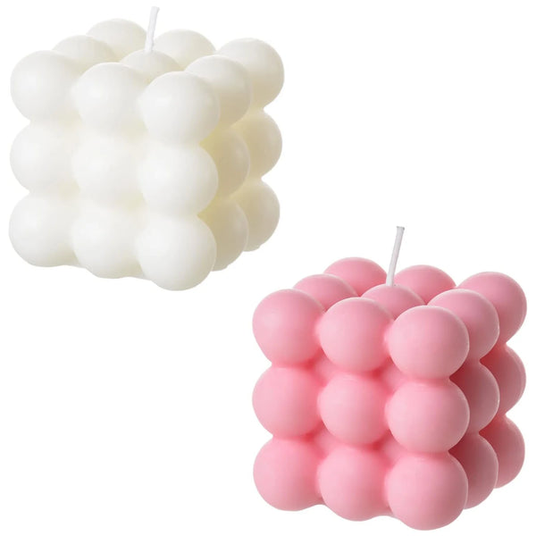 A set of two soy wax candles, one white and one pink, shaped like cubes.