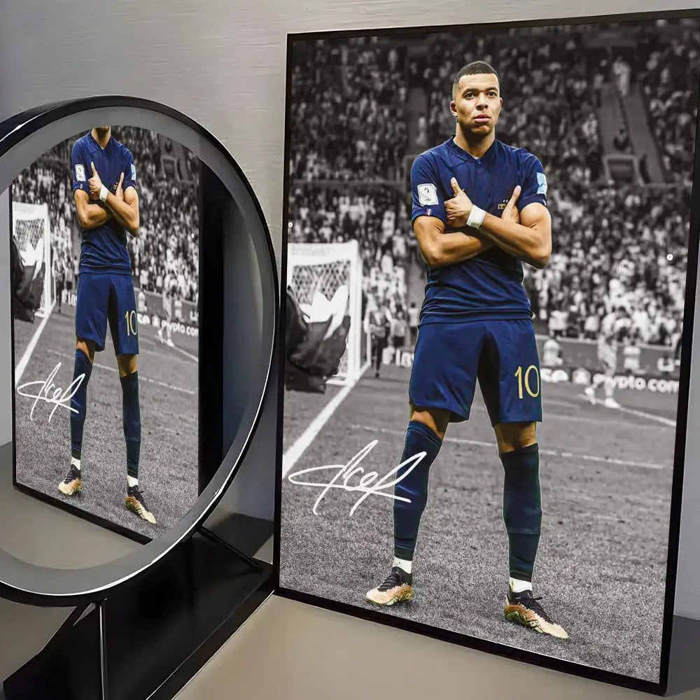 A portrait of a male athlete in a blue uniform standing on a soccer field, displayed in a framed poster.
