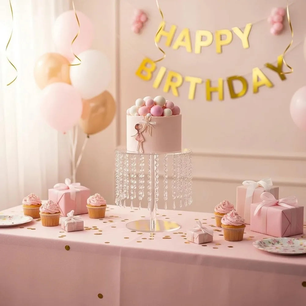 A pink birthday cake display featuring small cupcakes and balloons on a table.