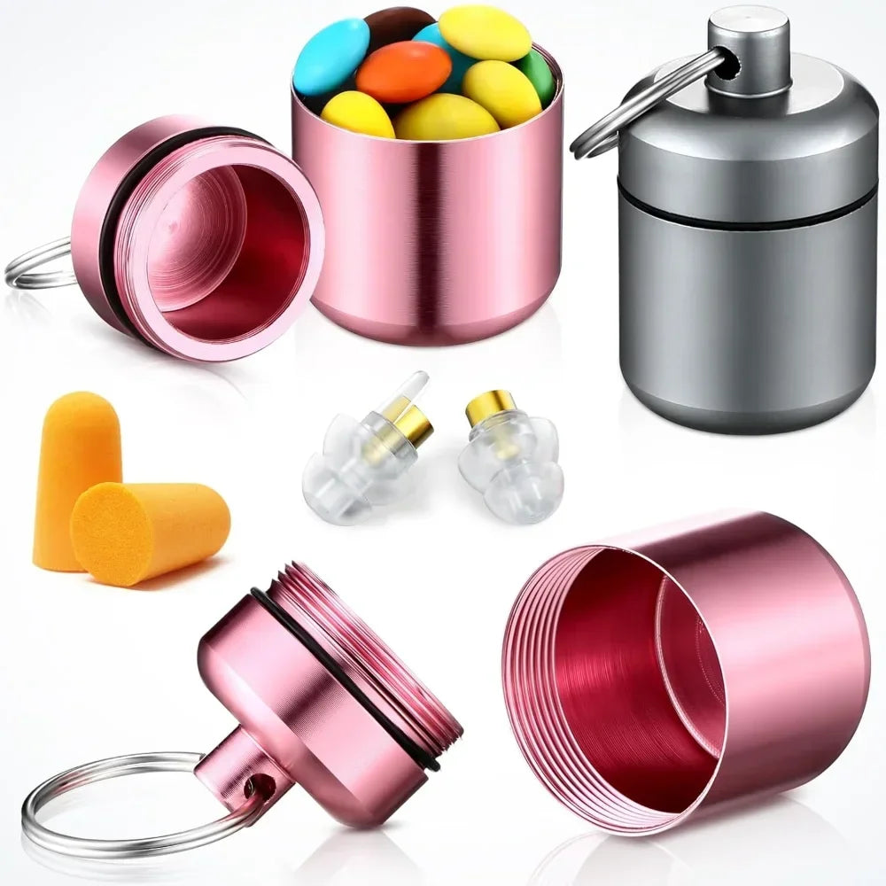 A pink pill organizer with a clear window and a silver cap, shown alongside various components and a keyring.