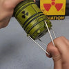 A hand holds a miniature nuclear reactor lantern with a green glow and protruding metal prongs.