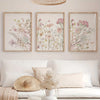 Three framed botanical prints featuring soft pink and muted green flowers on white backgrounds