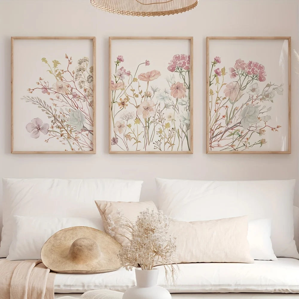 Three framed botanical prints featuring soft pink and muted green flowers on white backgrounds