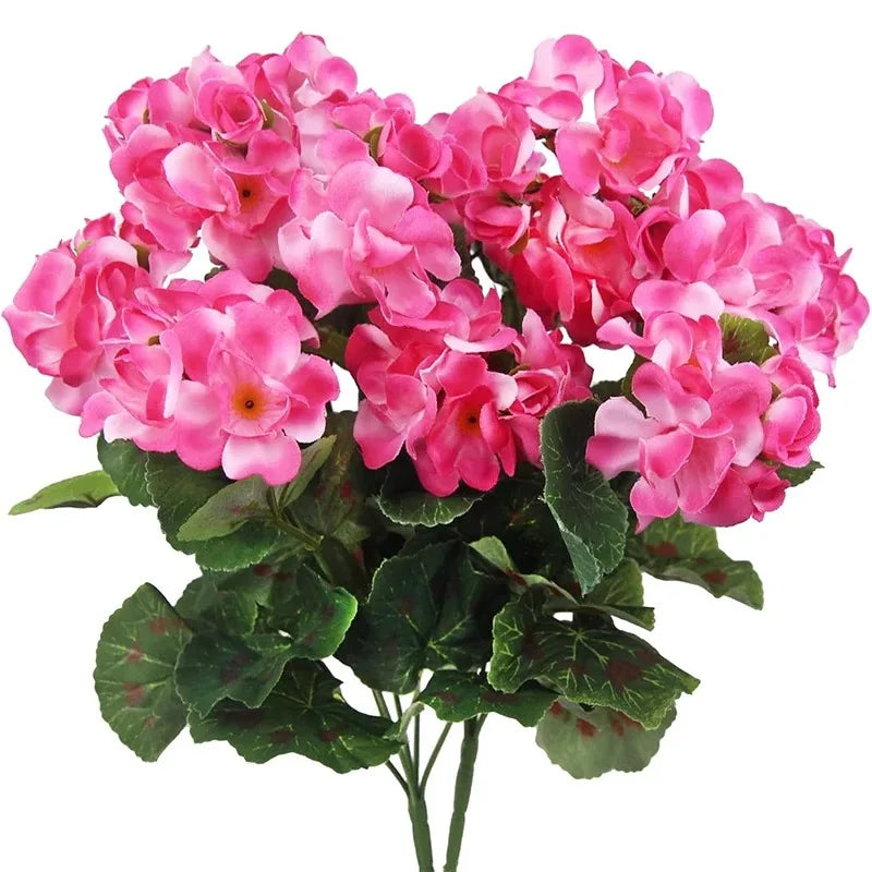 A bouquet of vibrant pink faux silk geranium flowers with green leaves for outdoor and indoor decor.