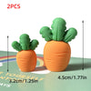 Two orange carrot cake toppers with green leafy tops displayed on a green surface.